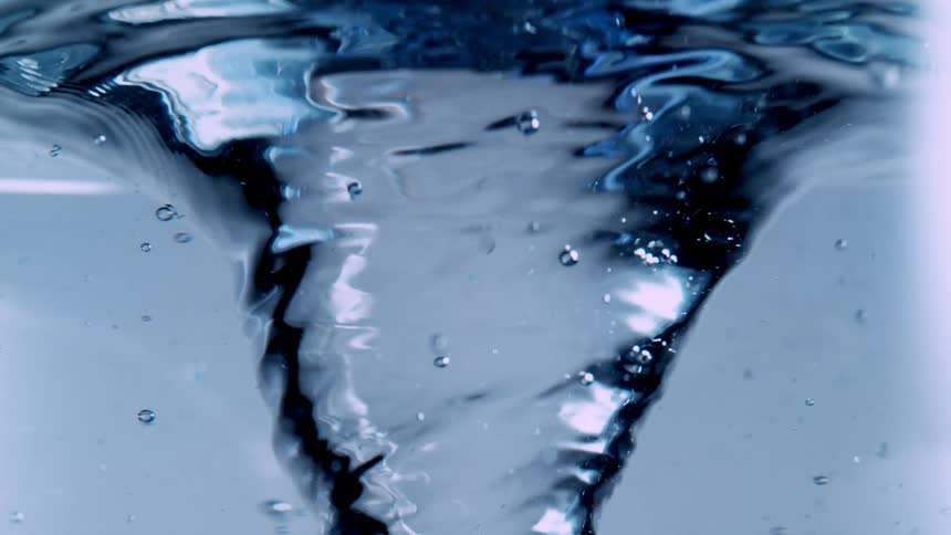 A close-up, slow-motion shot of a mesmerizing vortex of clear blue water swirling