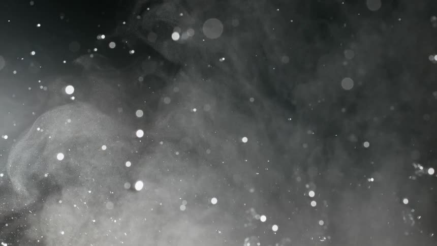 Slow motion of hot water splashing and creating steam against a dark background