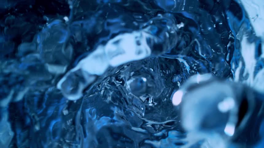 A captivating super slow-motion close-up of deep blue water swirling into a powerful vortex