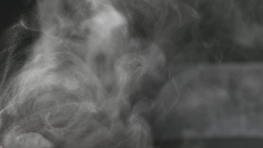 Slow motion macro shot of white mist swirling against a dark background