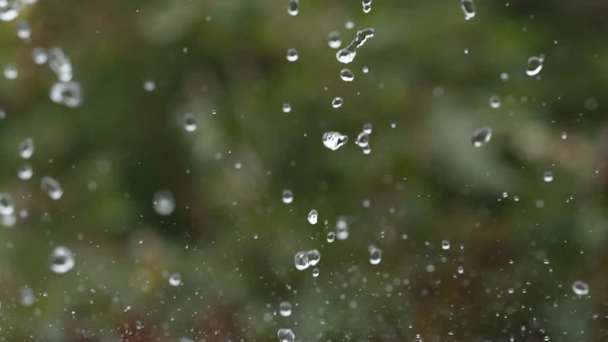 Mesmerizing close-up of glistening water droplets suspended in air in extreme slow motion