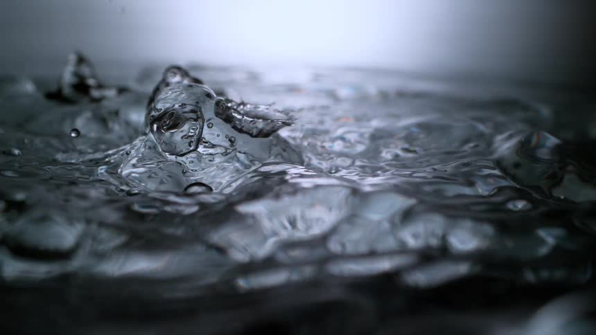 Dramatic super slow-motion shot of water pouring and creating intricate splashes and droplets