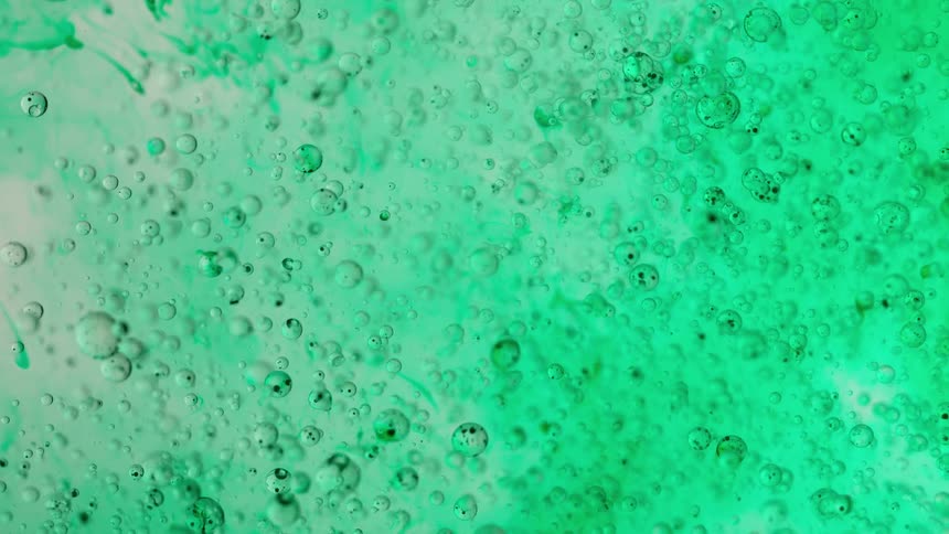 A mesmerizing macro shot of vibrant green liquid with countless small bubbles floating and slowly moving