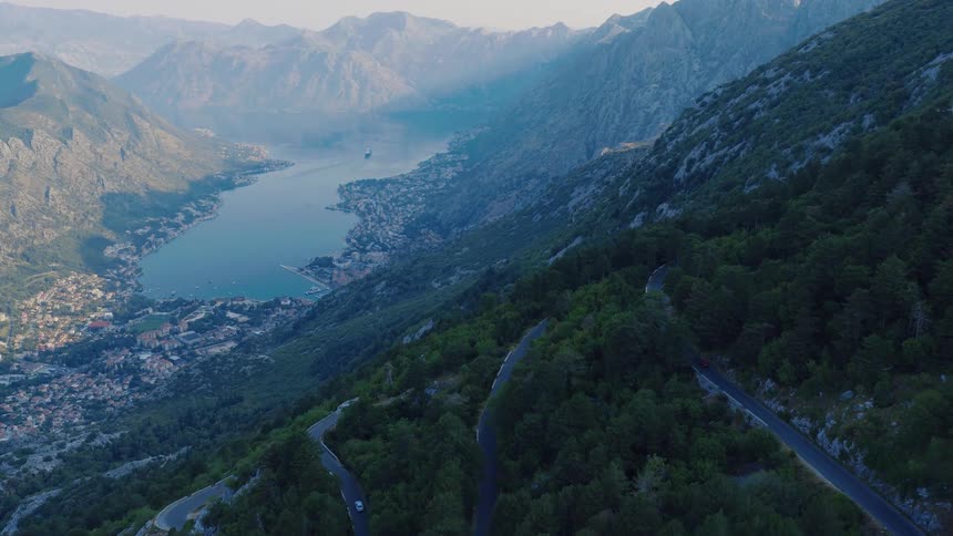 Aerial view of a winding serpentine road on a mountainside overlooking the stunning Bay of Kotor in Montenegro