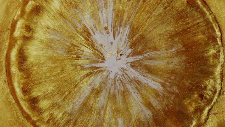 Mesmerizing slow-motion footage of a golden liquid abstract formation expanding in a circular shape