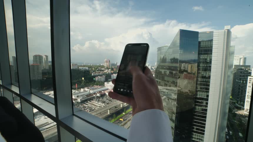 First-person perspective of a hand endlessly scrolling through a social media feed on a smartphone against a modern cityscape backdrop