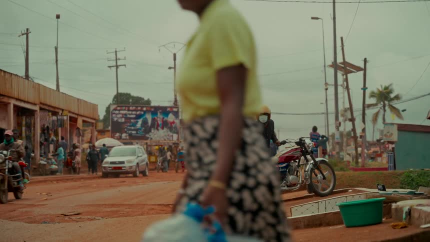 Slow motion captures the daily life on a busy dirt road in a developing African town