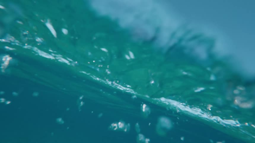 An ethereal slow-motion, underwater view of the tranquil surface of the ocean