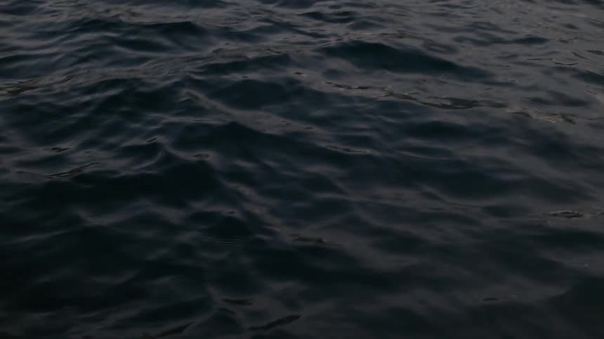 Dark, deep ocean water gently ripples in a mesmerizing pattern