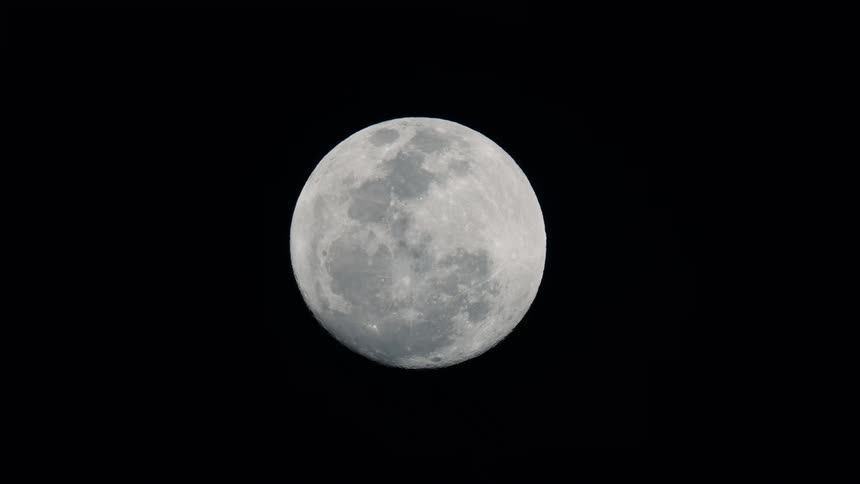 A detailed close-up of a bright full moon showing its craters against the vast blackness of the night sky