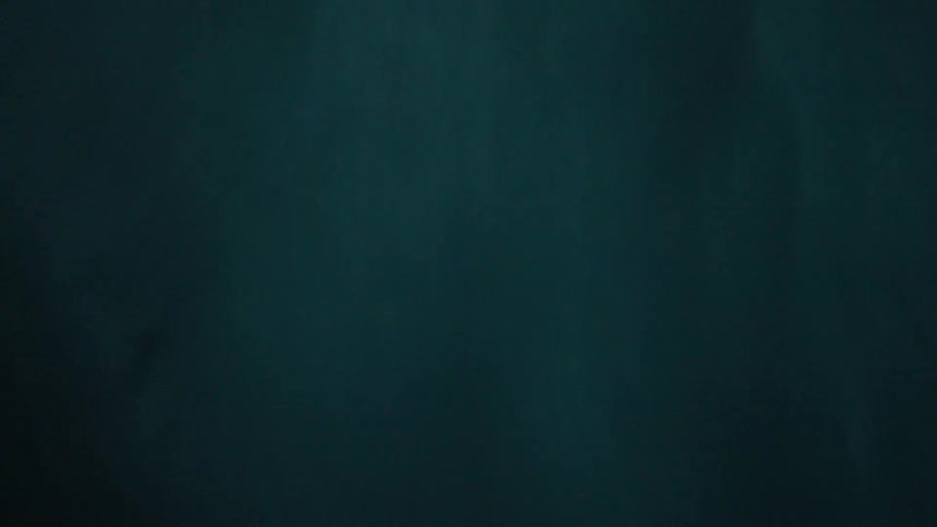 A first-person point of view shot of submerging into the deep dark ocean and rising up to the turbulent, foamy surface