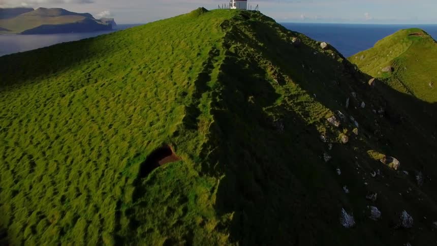 The mountain is all green with a tower at the top