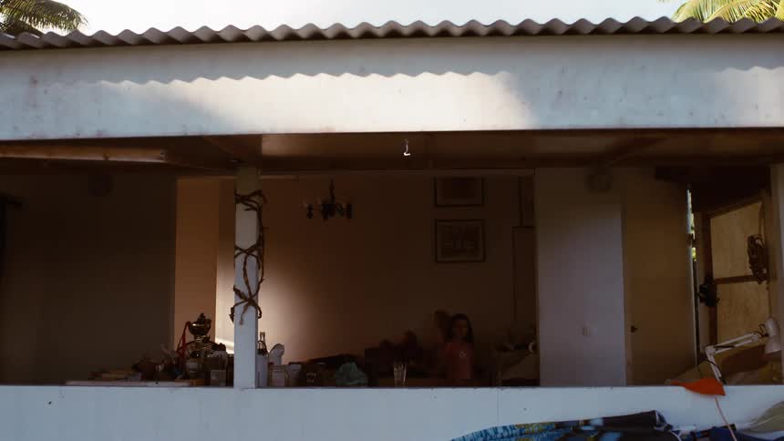 Sunlight moves across the room in a timelapse as a family relaxes together in their open-air home