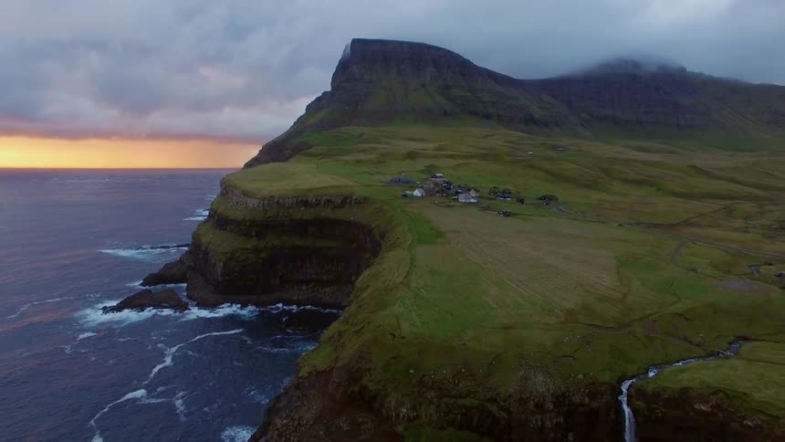Waterfall going into a sea on a cloudy sunset evening
