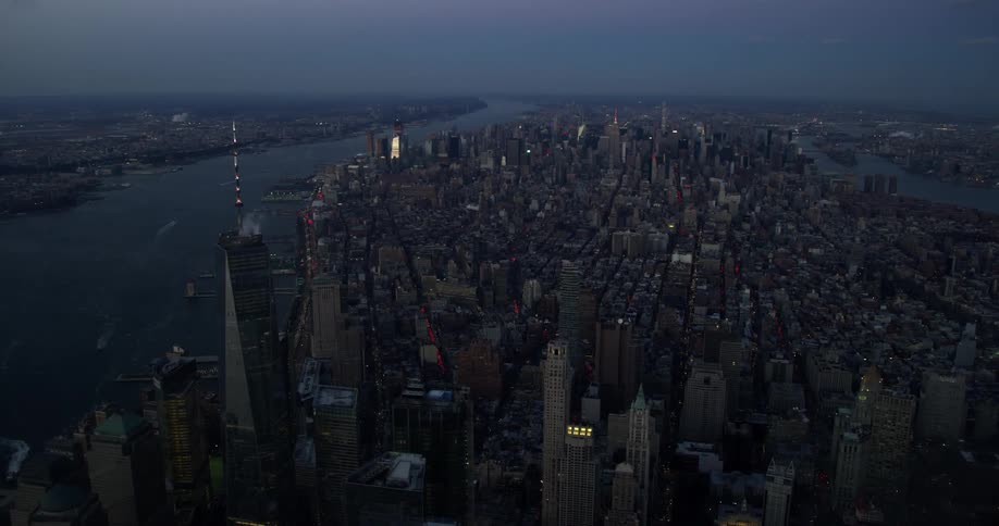 Aerial view of a city next to a river at night