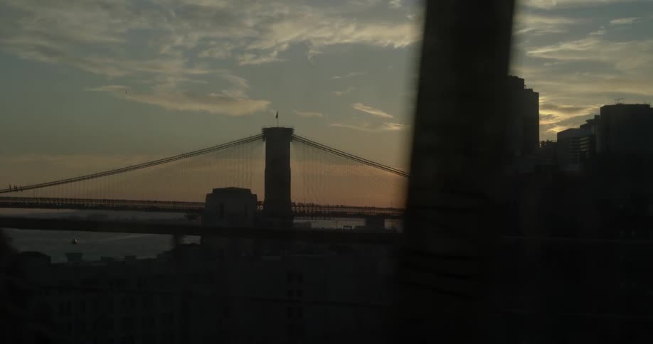 Moving view from a bridge in a large city at sunset