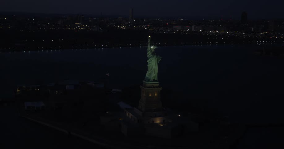 The statue of liberty and city lights at night