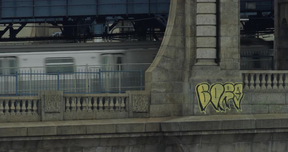 A train runs across a bridge with graffiti on it