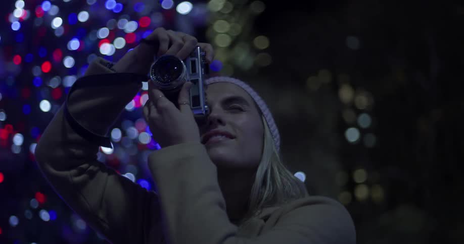 A woman looks up taking a photograph