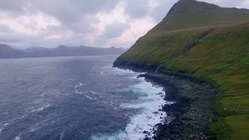 Water splashing to shore near mountains