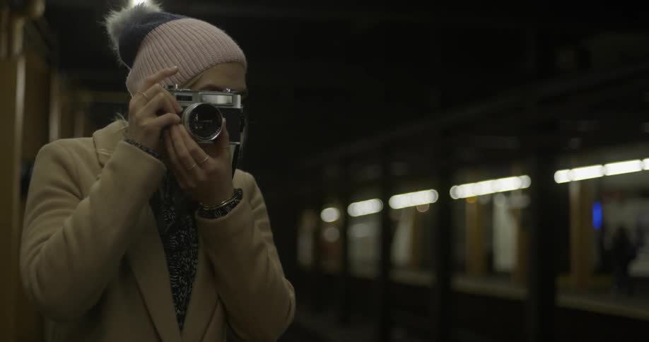Woman taking pictures in a subway station