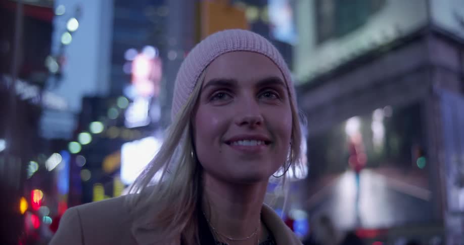 A woman smiles and laughs after taking a selfie with another woman