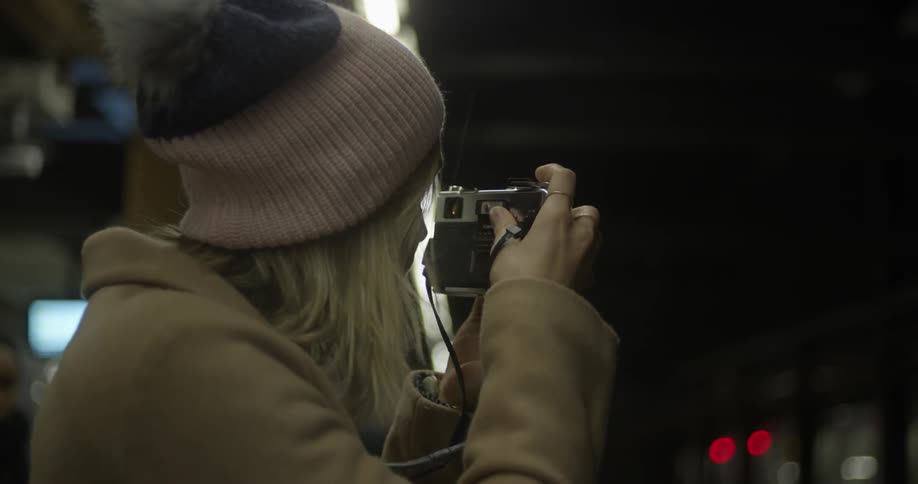 Woman taking pictures in a subway station