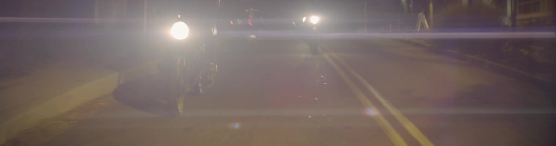 Motorcyclists riding on a city street at night