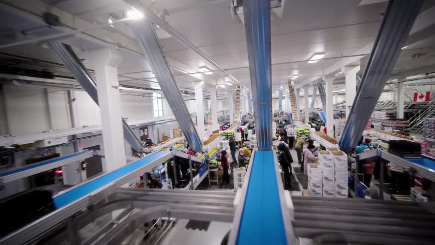 A sweeping cinematic tour through a massive, modern food processing and packaging plant with automated conveyor belts and busy workers