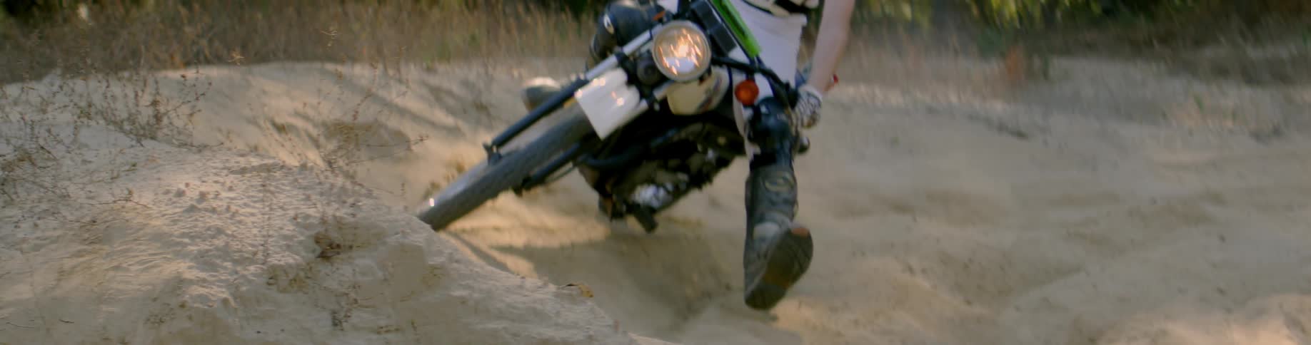 A person makes a turn on a motorcycle in the sand