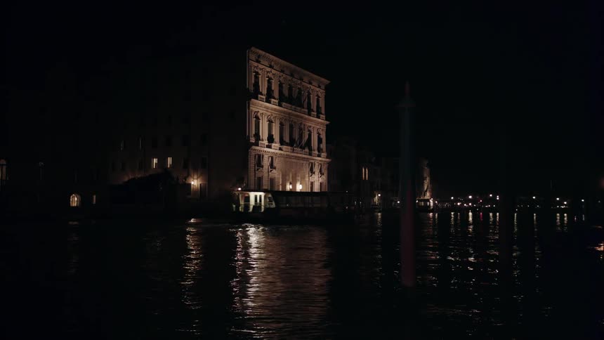 A boat floats on a body of water with a building nearby