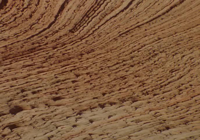 A slow zoom out reveals the intricate, curved layers and striations of a red sandstone rock formation