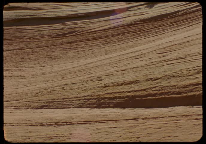 Vintage archival footage of a close-up on a layered sandstone rock formation