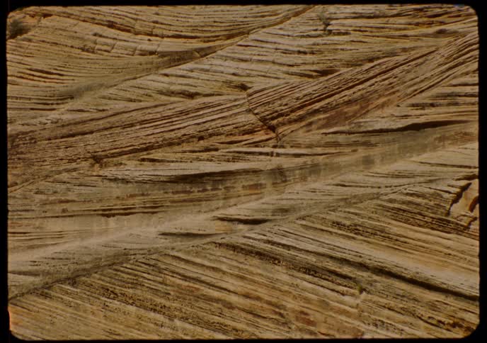 An archival close-up reveals the intricate patterns and diagonal striations of a sandstone rock formation