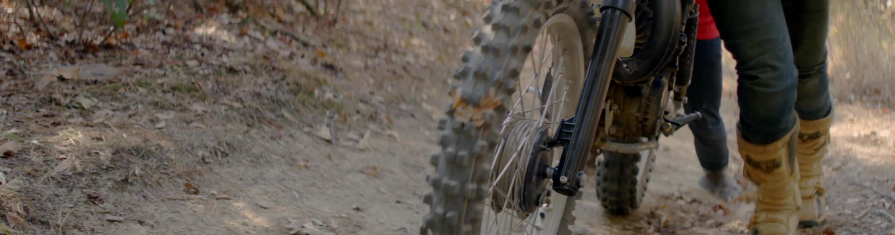Knobby motorcycle tires roll along the dirt road