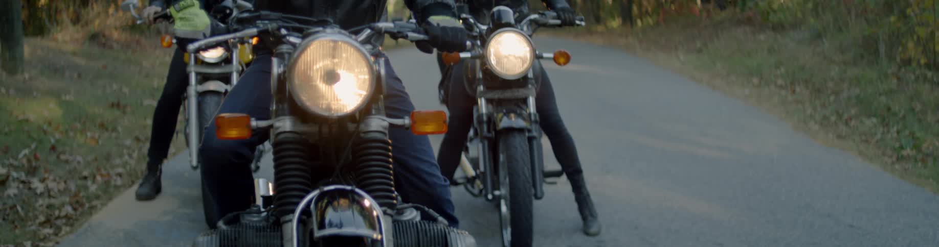 People are sitting on motorcycles waiting