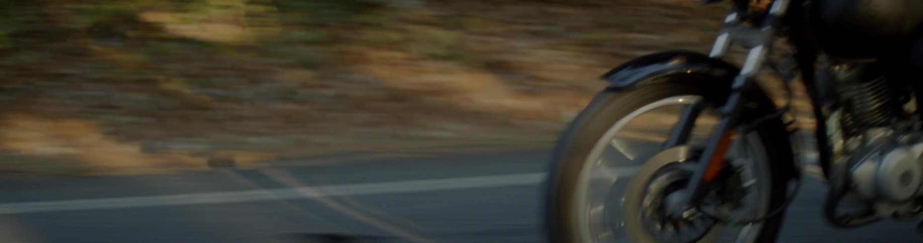 A motorcycle rides fast down the road