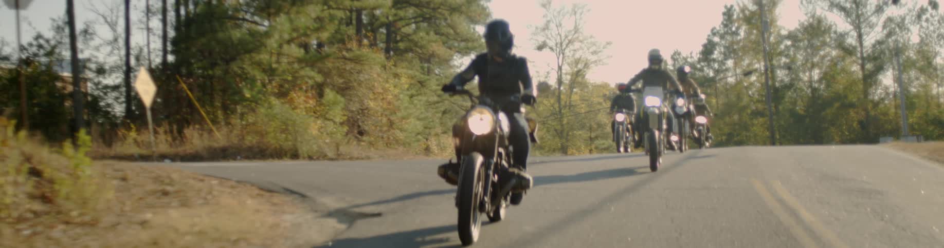 People ride their motorcycles down the street together