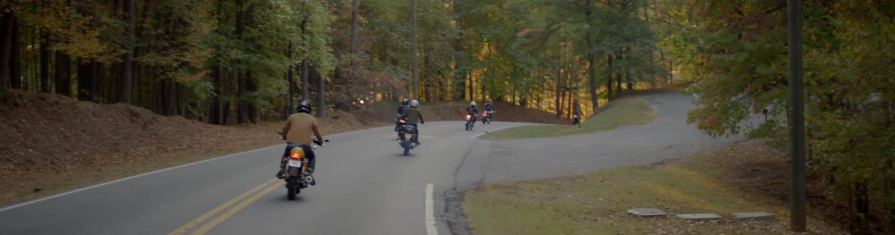 Group of motorcyclists riding down a rural road