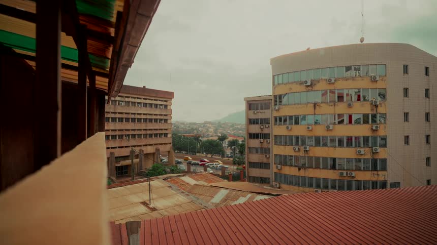 A high-angle view of an urban landscape in Africa, showcasing varied architecture under a cloudy sky