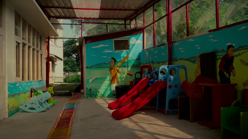 A quiet and empty children's play area with colorful toys and murals awaits its young visitors
