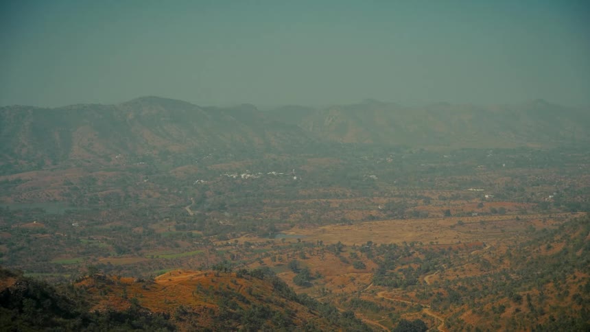 Expansive wide view of an arid mountain valley landscape on a hazy day