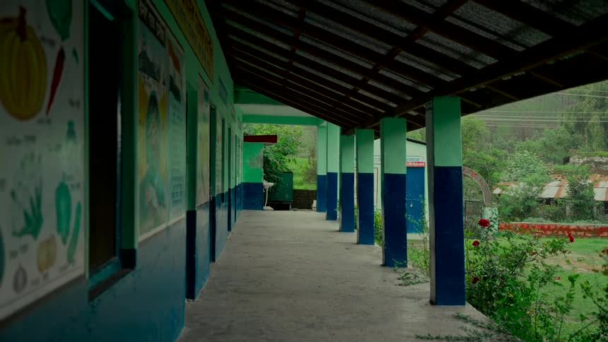 A quiet, empty outdoor hallway of a rural school on an overcast day