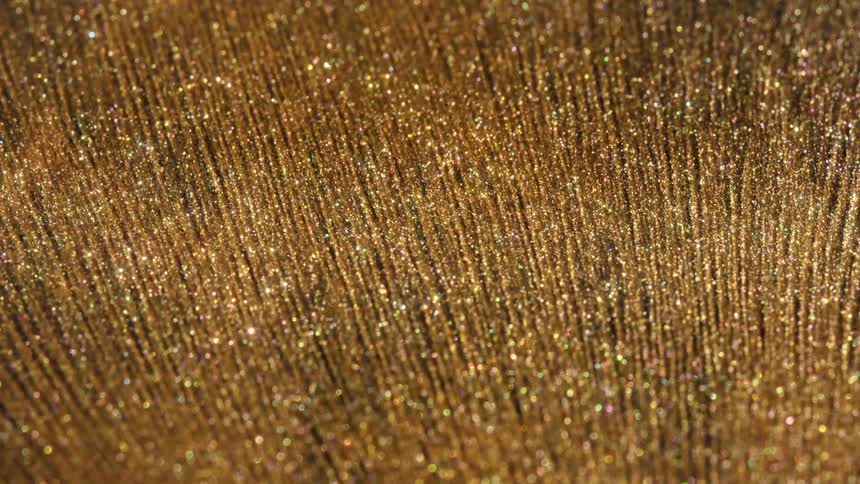 A mesmerizing macro shot of a sparkling gold surface with iridescent glitter