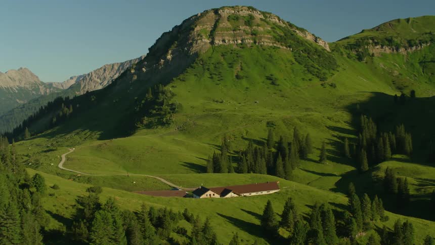 A house sits at the end of a narrow road in a mountain valley