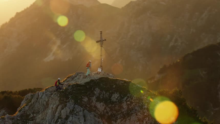 Cross on top of a mountain at sunrise