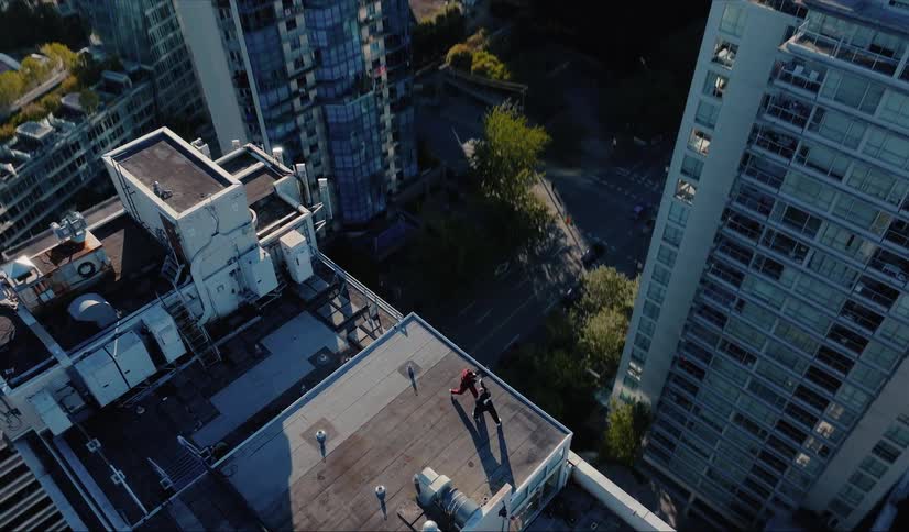 Epic aerial shot reveals two superheroes in a dramatic standoff on a skyscraper rooftop overlooking the city