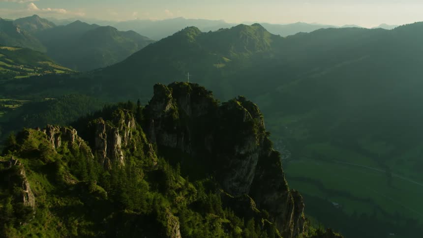 The mountains are very high with a cross at the top