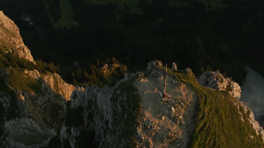 Cross on top of a mountain at sunrise
