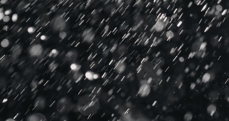 A dramatic black and white slow-motion close-up of water droplets splashing onto human skin